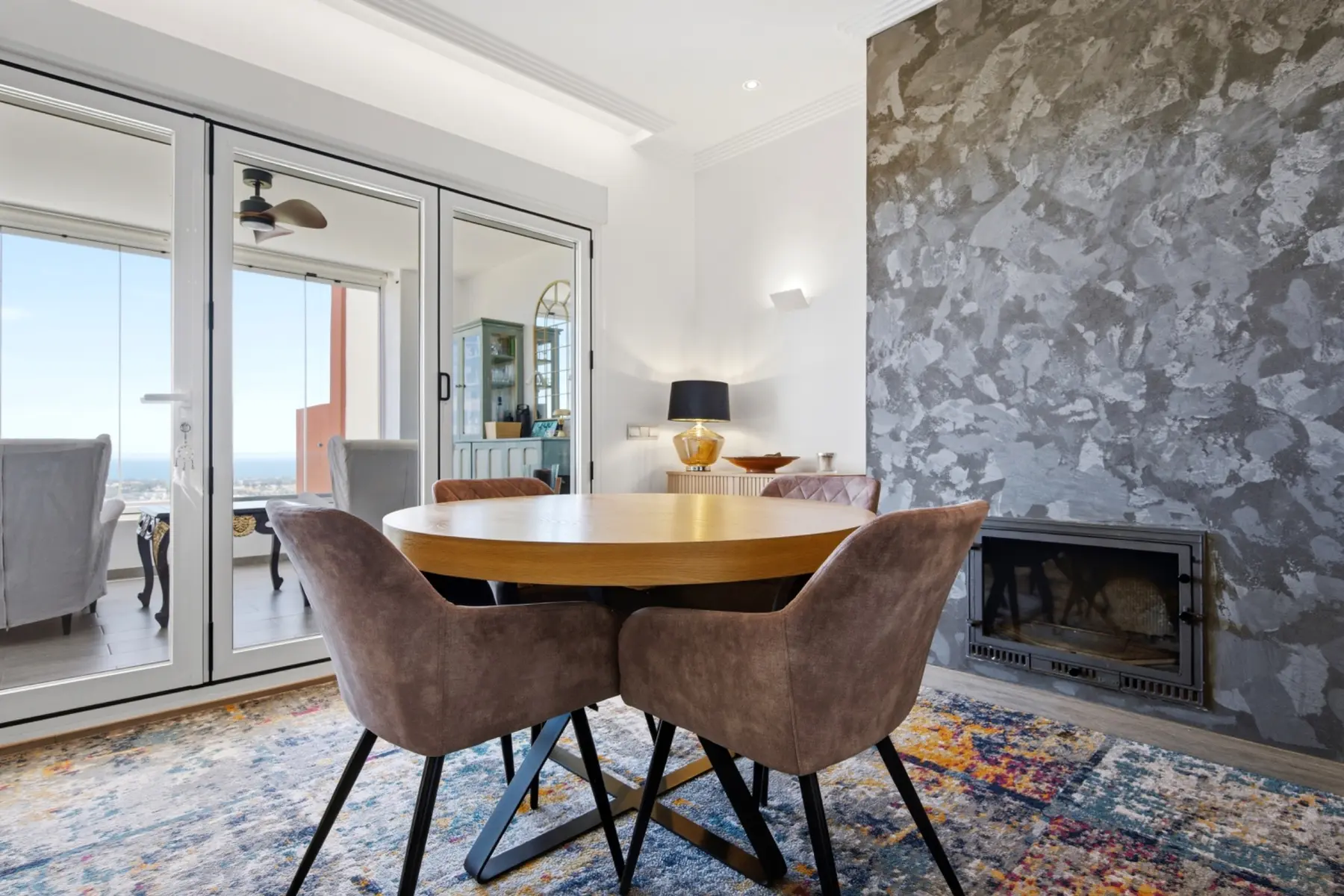 Comedor acogedor con chimenea y acceso a una terraza en Benahavís