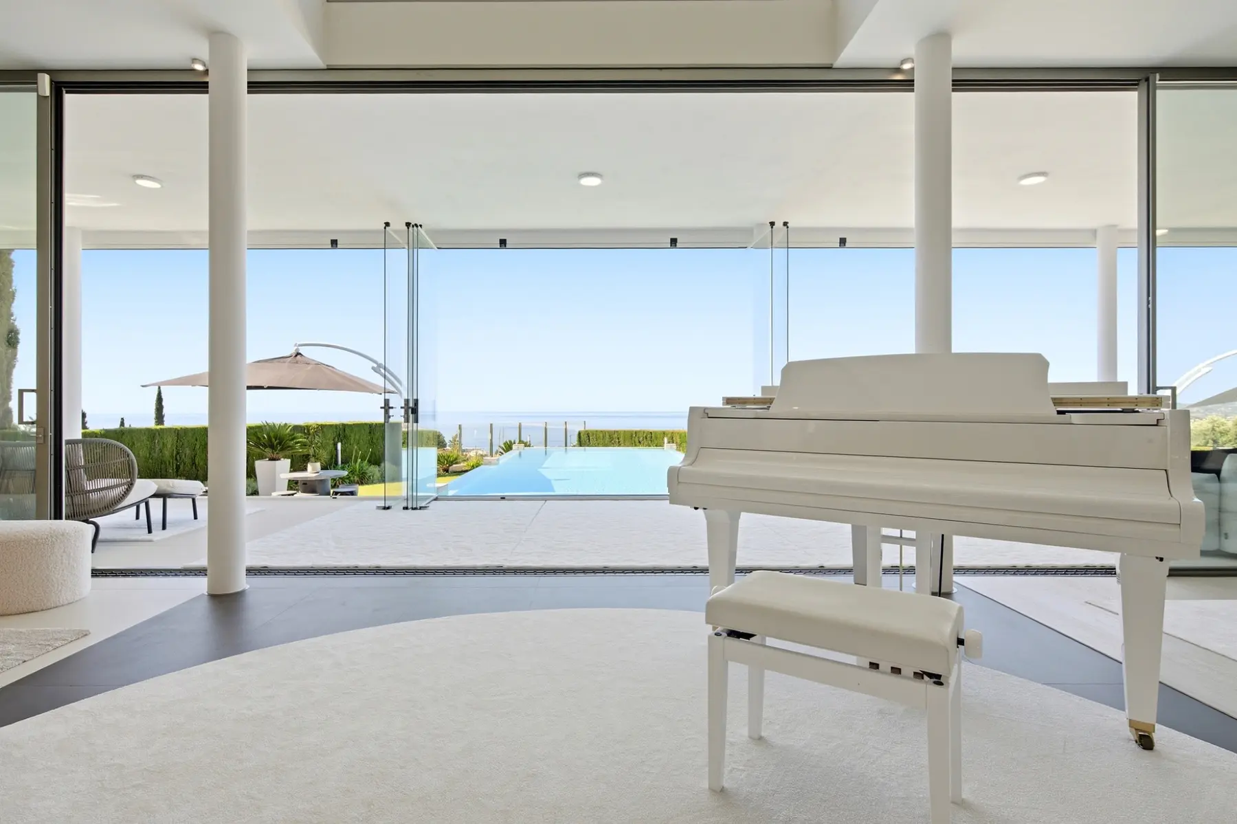 Piano blanco frente a una terraza con vistas al mar en una villa de El Higuerón