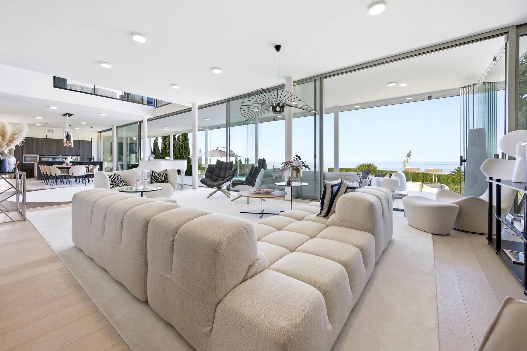 Salón de planta abierta conectado con la piscina y el mar en El Higuerón