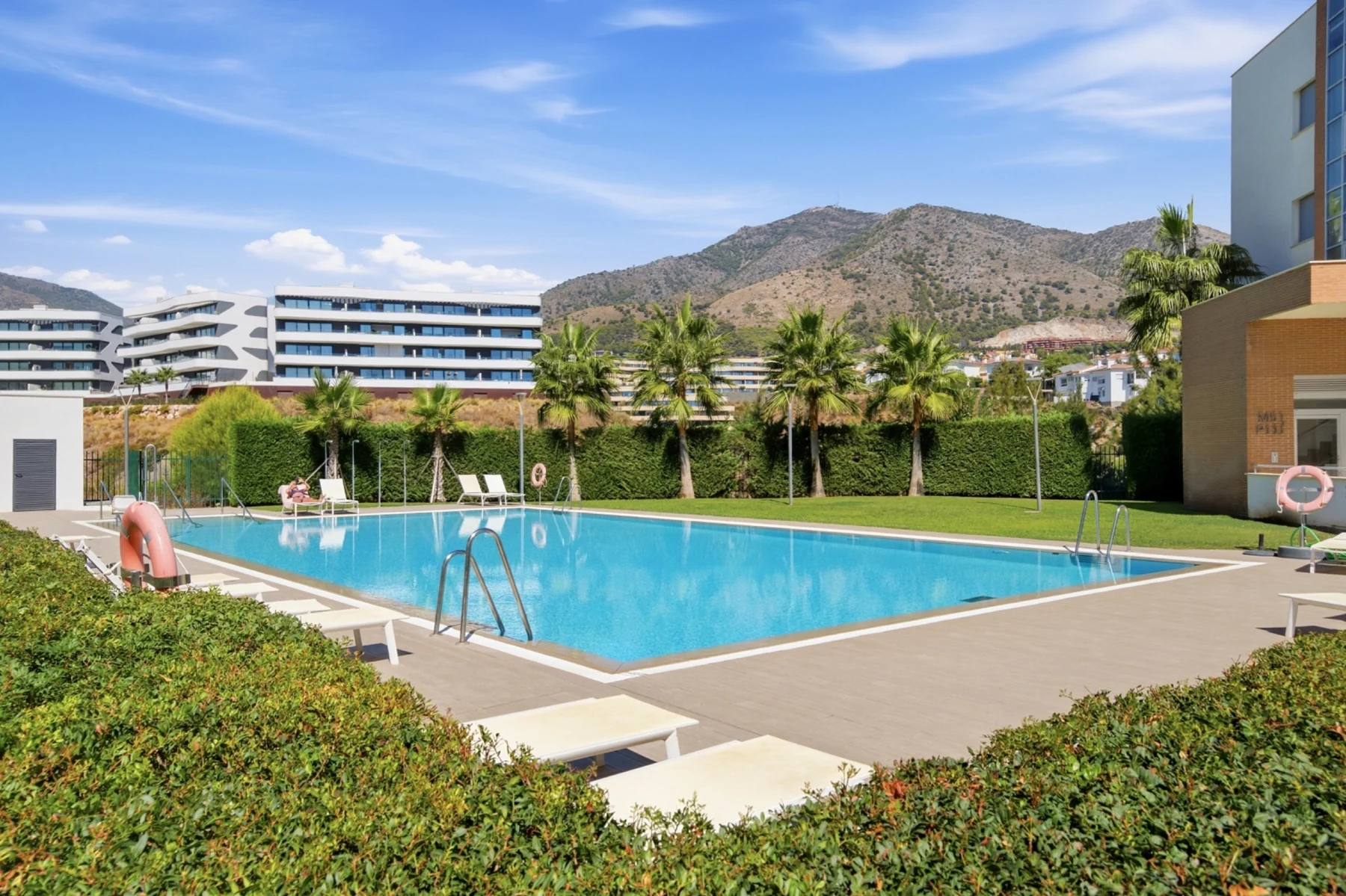 Piscina comunitaria con la sierra de Mijas al fondo en Fuengirola