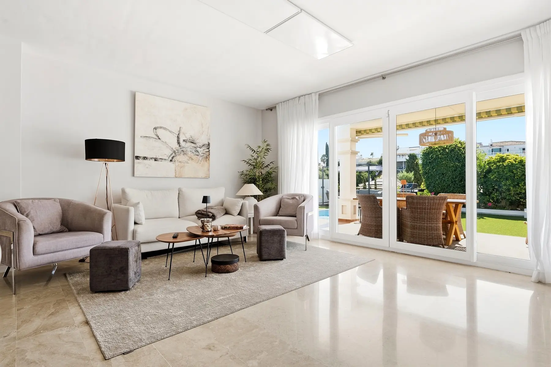 Salón luminoso abierto hacia la terraza y el jardín en una vivienda de Mijas Costa