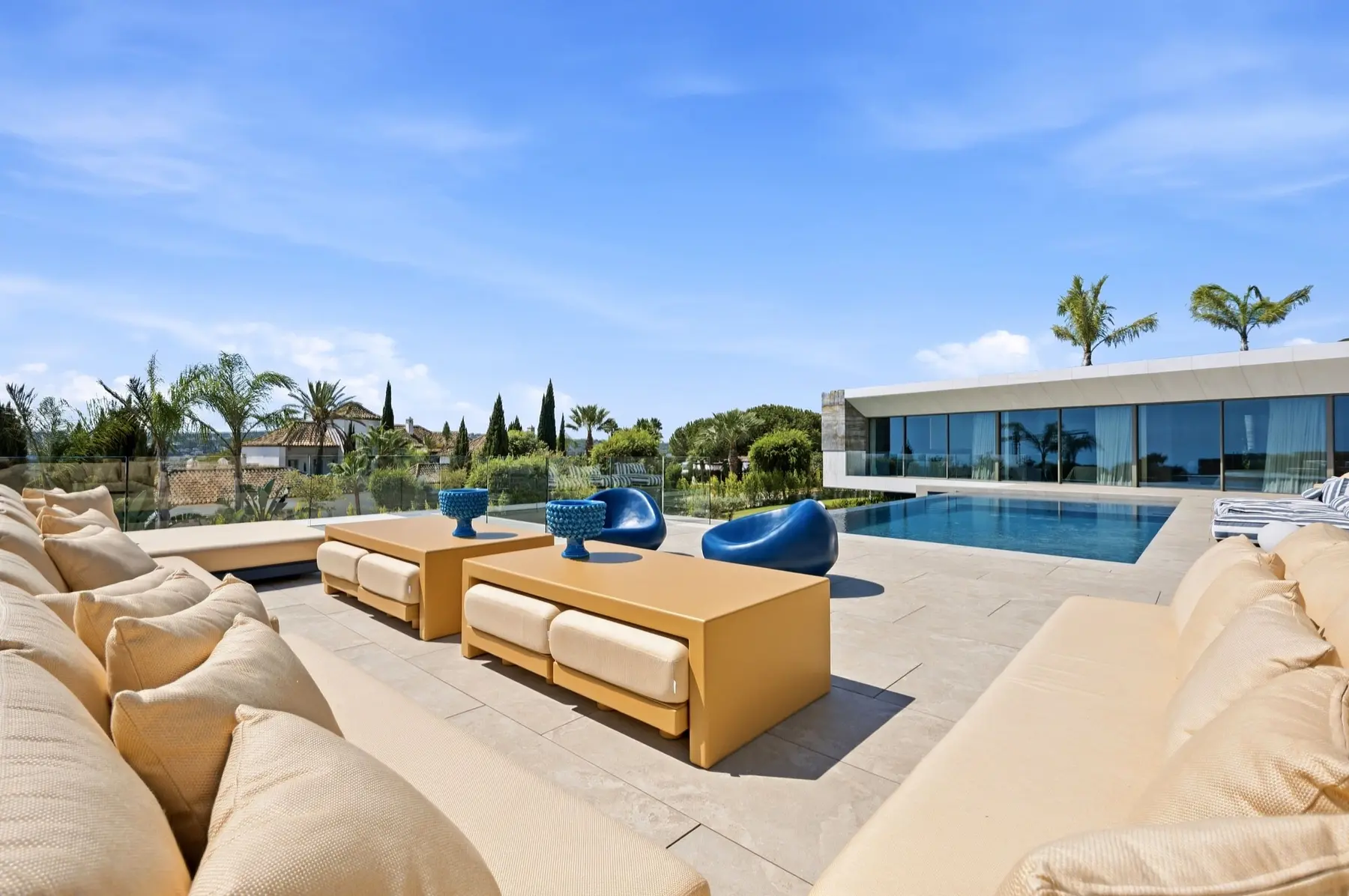 Zona de estar exterior junto a la piscina de una villa contemporánea en Sotogrande