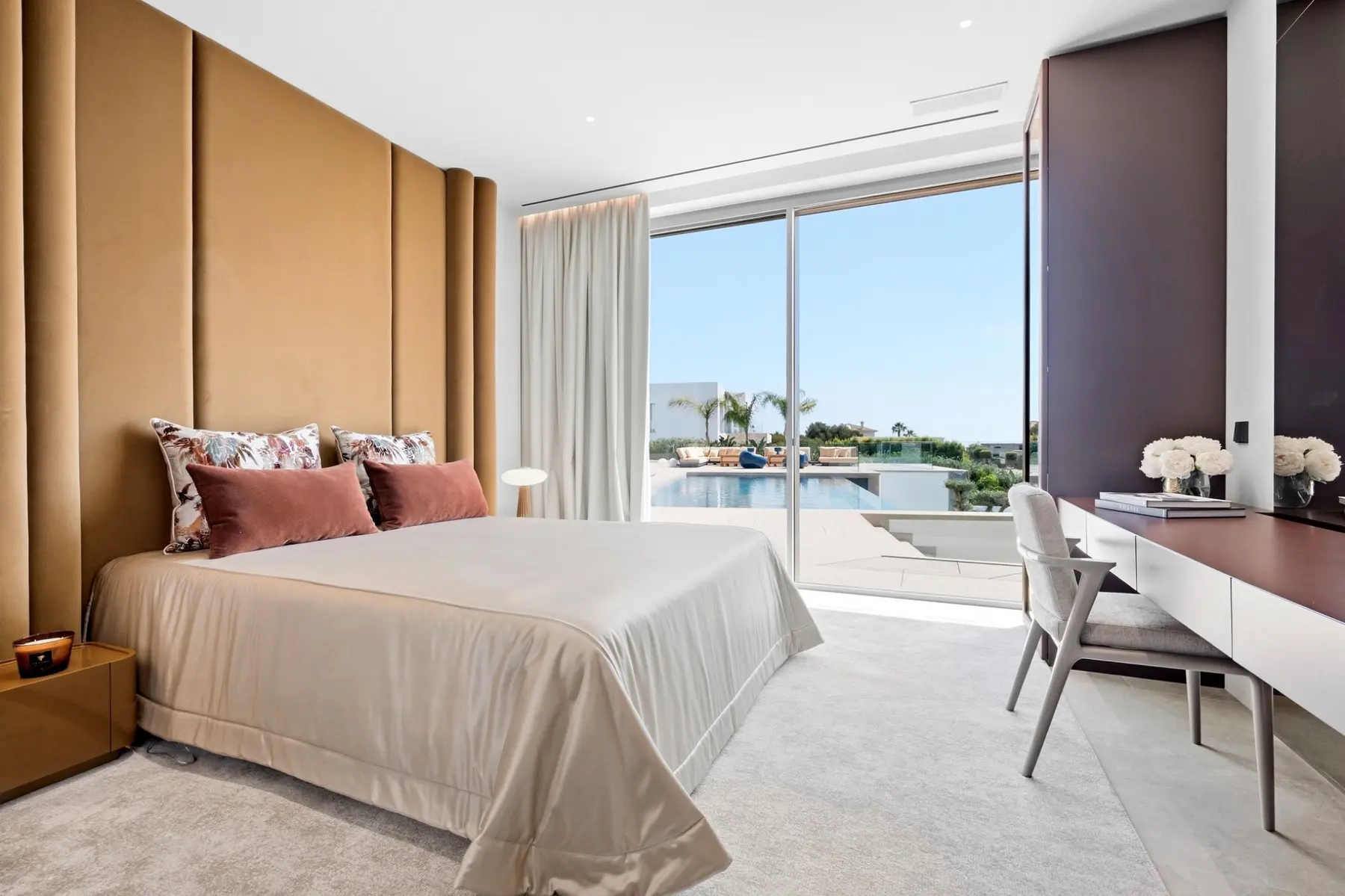 Dormitorio principal con acceso visual a la piscina en una villa de Sotogrande