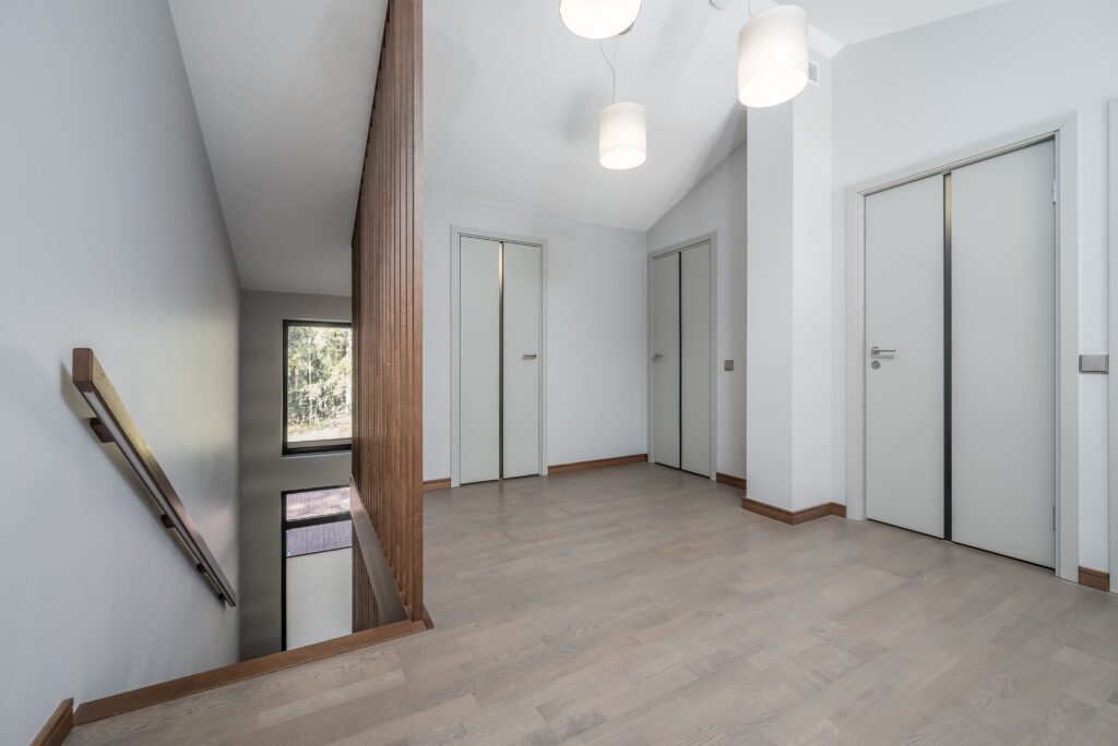 Fotografía inmobiliaria de recibidor amplio con escalera, puertas interiores y distribución funcional