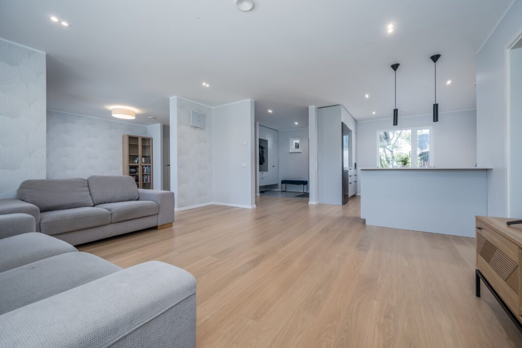 Fotografía inmobiliaria de salón amplio con cocina abierta y distribución moderna