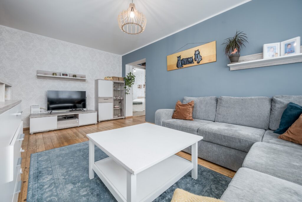 Fotografía inmobiliaria de salón con sofá, zona de estar y distribución funcional