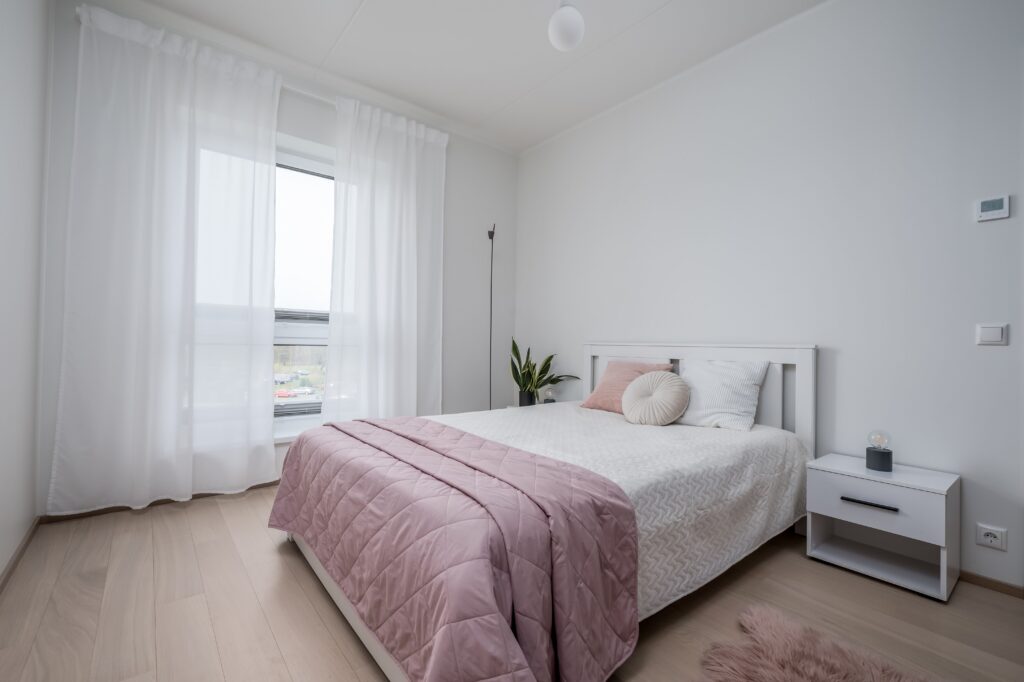 Fotografía inmobiliaria de dormitorio luminoso con decoración minimalista y luz natural