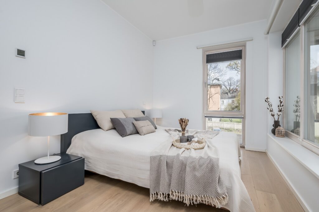 Imagen de dormitorio moderno con luz natural y estilo minimalista para fotografía inmobiliaria profesional