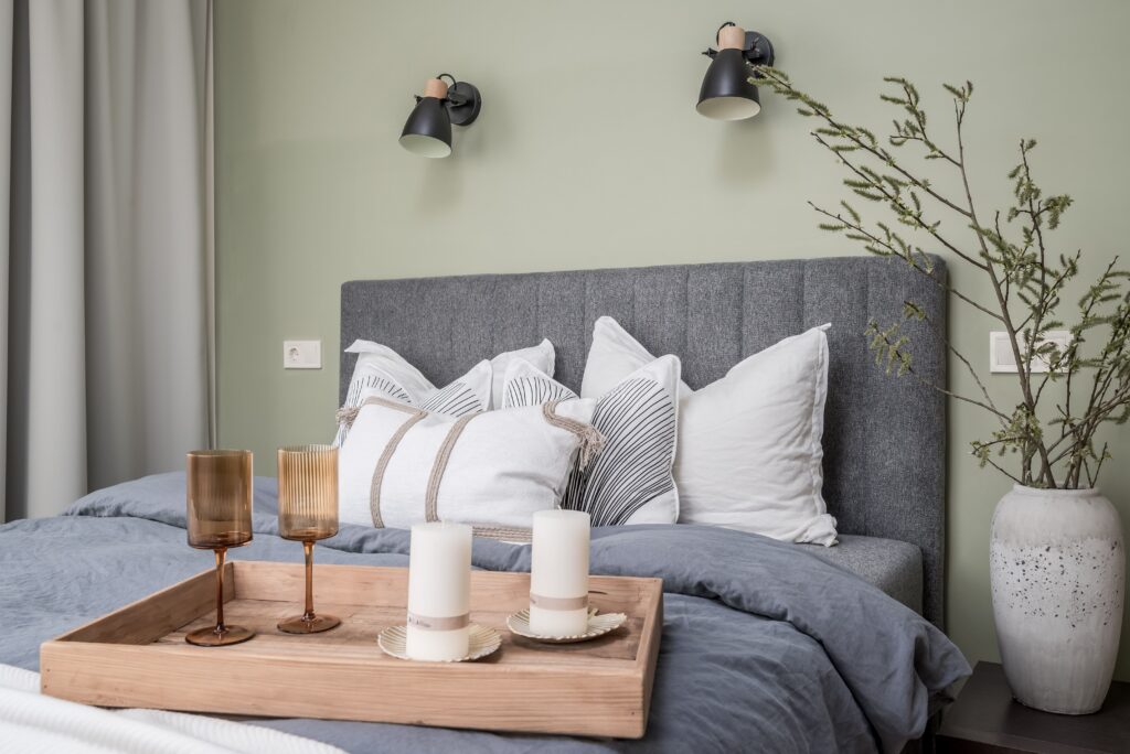 Fotografía inmobiliaria profesional de dormitorio elegante con cama decorada, luz natural y estilo moderno en Málaga