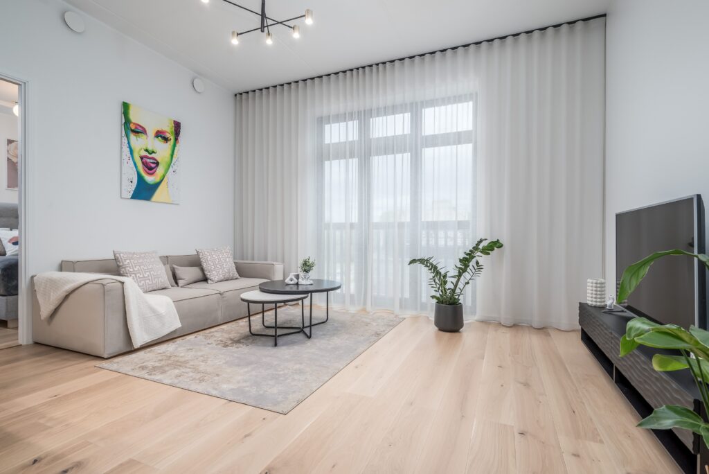 Fotografía inmobiliaria profesional de salón luminoso con ventanales grandes, utilizada en marketing de propiedades para agencias inmobiliarias