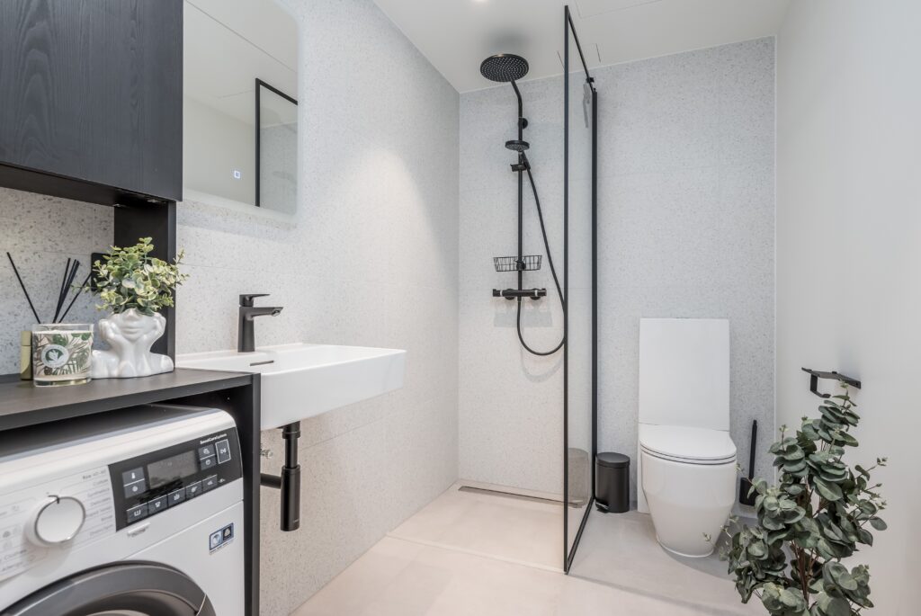 Fotografía inmobiliaria de baño moderno con ducha de cristal y diseño minimalista para anuncios de propiedades