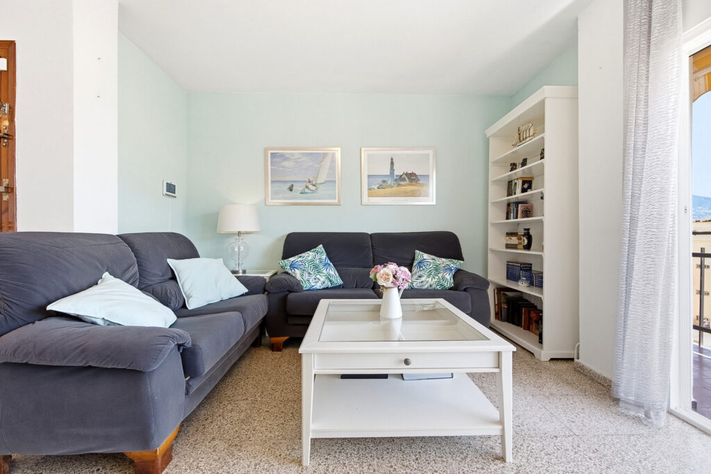 Fotografía inmobiliaria en Fuengirola – salón moderno con sofá, mesa de centro y luz natural, Costa del Sol